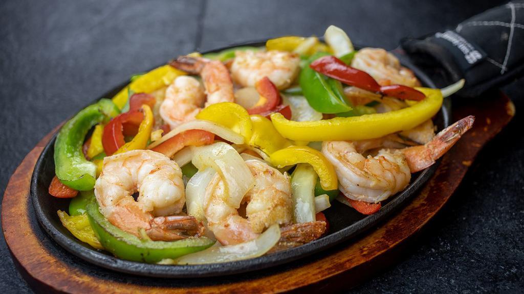 Fajitas De Camaron · A sizzling hot choice accompanied by caramelized Spanish onions, diced tomato, sautéed bell peppers, and shrimp. Served with Mexican rice, refried beans, and sour cream.