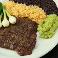 Carne Asada · Charbroiled skirt steak. Served with Mexican rice, black beans, guacamole, grilled onions, a...