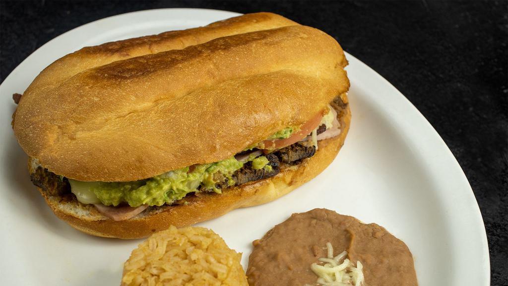 Torta Cubana Con Arroz Y Frijoles · Torta Cubana with Mexican rice and refried beans.