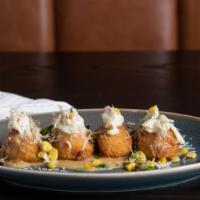 Crab Hushpuppies · Blue crab, cheesy fritters, grated manchego, sweet corn butter sauce.