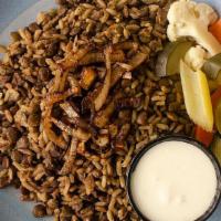 Mujadra · Lentils, rice, and caramelized onions, served with pickled vegetables and yogurt.  . (vegeta...