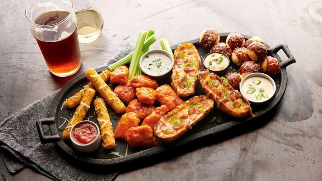 Classic Sampler Platter · Mozzarella bricks, potato skins, pretzel bites, and boneless wings tossed in your choice of sauce. Served with marinara, seasoned sour cream, queso, and ranch or bleu cheese dressing.