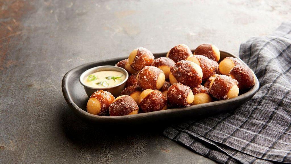 Pretzel Bites · Baked to perfection and tossed with Kosher salt. Served with a side of queso