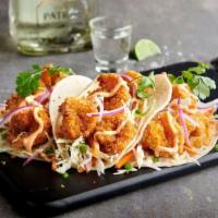Crispy Shrimp Tacos · Fried shrimp topped with shredded cabbage mix, red onion, cilantro and Boom-Boom sauce. Serv...
