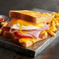 Loaded Grilled Cheese · Parmesan sourdough toast, American and cheddar cheese, applewood bacon, ham, tomato and an o...