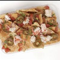 Lobster Nachos · Classically prepared nachos with our house made old bay seasoned queso sauce, topped with to...