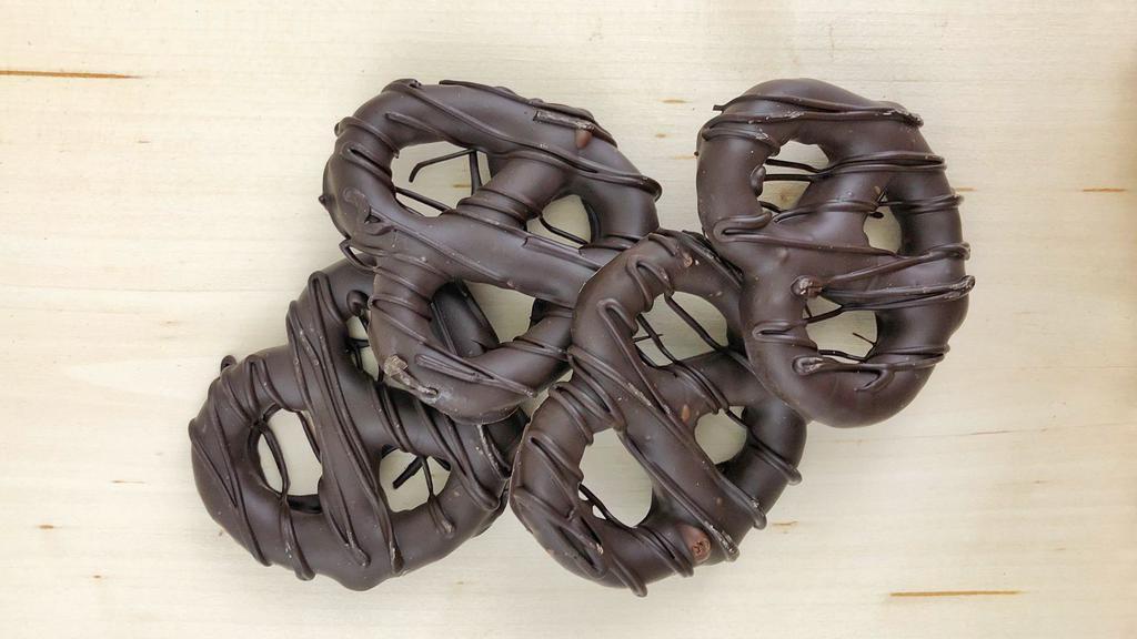 Pretzels - Dark · Four pretzels enrobed in 52% cacao dark chocolate, drizzled with dark chocolate and packaged in a clear box. Contains wheat.