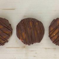 Turtles - Milk · Three 1.5oz turtles. Caramel and pecan pieces are mixed together then dipped and drizzled wi...
