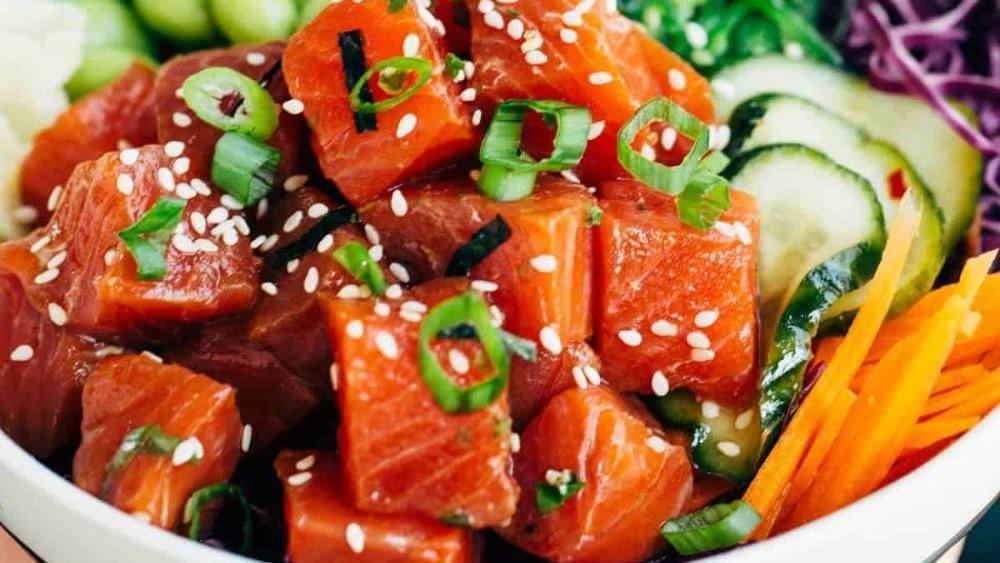 Poke Mazing · Spicy tuna(raw), salmon (raw), lettuce, cucumber, avocado, edamame, corn, cherry tomato, seaweed salad, carrot. With Thai sweet chili, eel sauce, fried garlic on top.