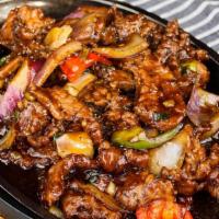 092 Sizzling Beef · Tender sliced beef, bell peppers, and onions in black bean sauce on a sizzling platter.