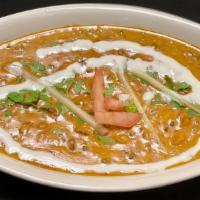 Dal Bhukara · Rich, creamy slow cooked whole urad dal (black gram) with tomato puree, butter and cream.