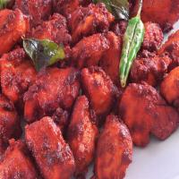 Chicken 65 · Tender pieces of chicken marinated with ginger, garlic, and Indian spices, garnished with cu...