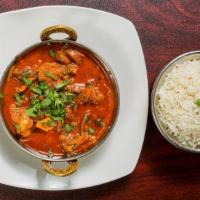 Goat Curry Masala · Bone-in goat meat cooked home-style in authentic herbs and spices. Served with basmati rice.