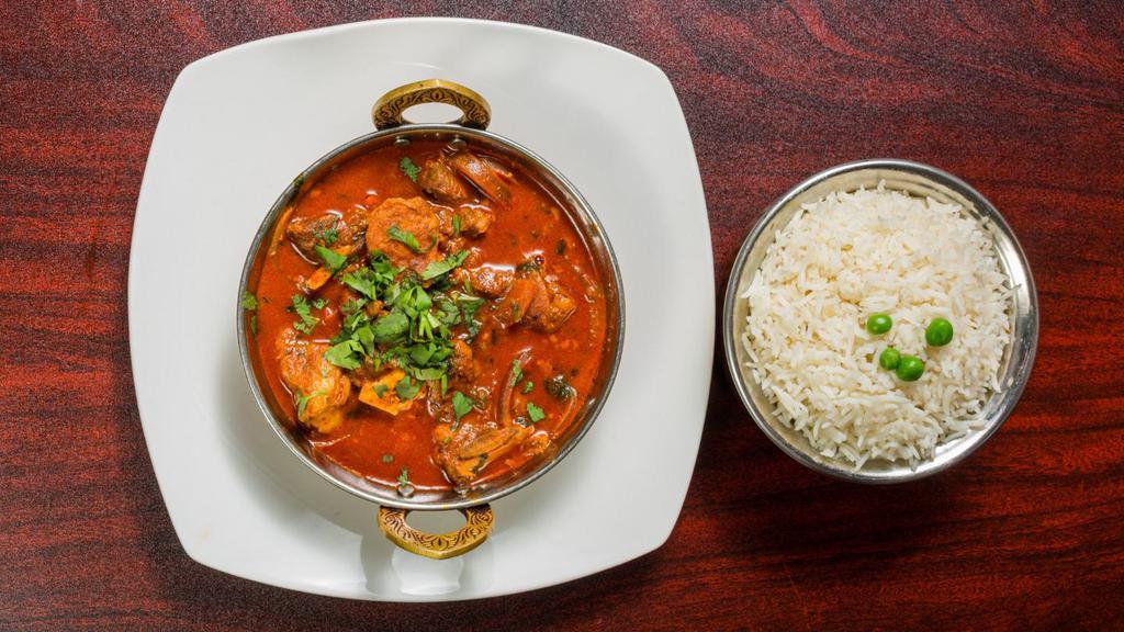 Goat Curry Masala · Bone-in goat meat cooked home-style in authentic herbs and spices. Served with basmati rice.