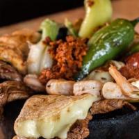 Molcajete Mexicano · Grilled pork, steak, chicken, shrimp and chorizo cooked with mushrooms, squash, zucchini, Me...