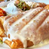 Classic Chimichanga · Two deep-fried flour tortillas filled with shredded beef or chicken, topped with cheese sauc...