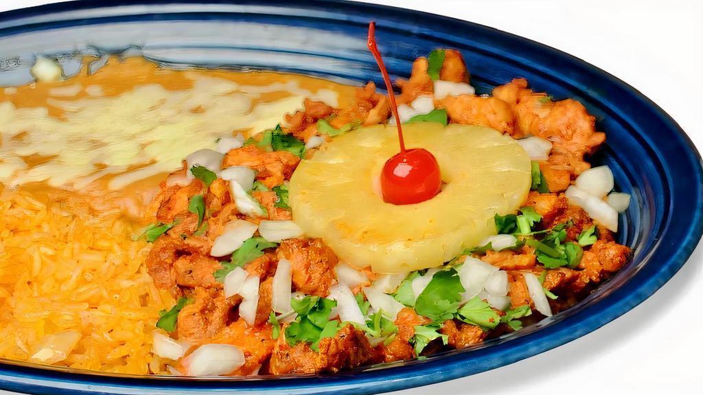 Al Pastor Especial · Pork tenderloin marinated in special pineapple sauce cooked with onions. Covered with melted cheese. Garnished with pineapple slices, a cherry and cilantro. Served with rice, beans and your choice of corn or flour tortillas on the side.