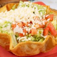 Taco Salad · Crispy flour tortilla bowl filled with your choice of chicken or ground beef, lettuce, tomat...