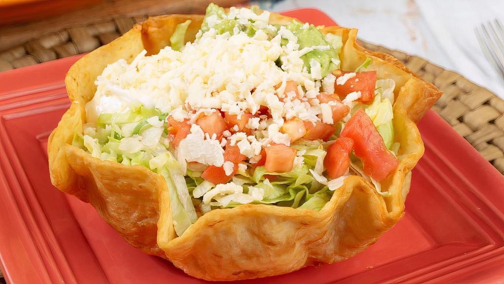 Taco Salad · Crispy flour tortilla bowl filled with your choice of chicken or ground beef, lettuce, tomatoes, sour cream and guacamole.