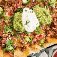 Large Nachos · Tortilla chips layered with beans, cheese, tomatoes, sour cream and guacamole.