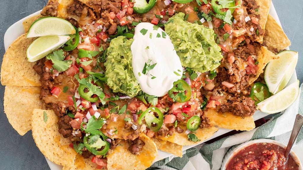 Large Nachos · Tortilla chips layered with beans, cheese, tomatoes, sour cream and guacamole.