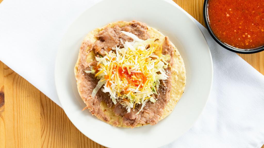 Tostada · Beans, lettuce, house taco sauce and Parmesan cheese.