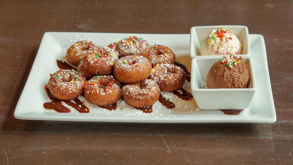Mini Donut Dunkeroos · fried mini donuts, dusted with powdered sugar, served with Nutella & vanilla frosting for dipping