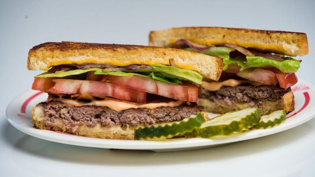 Pop Burger · Wow, this is one great burger! No wonder our mascot Mr. Pop wanted this named after him! This Angus burger is topped with American and Swiss cheese, bacon, grilled red onions, lettuce, tomato and Thousand Island dressing served between two pieces of grilled sourdough bread. Yum!