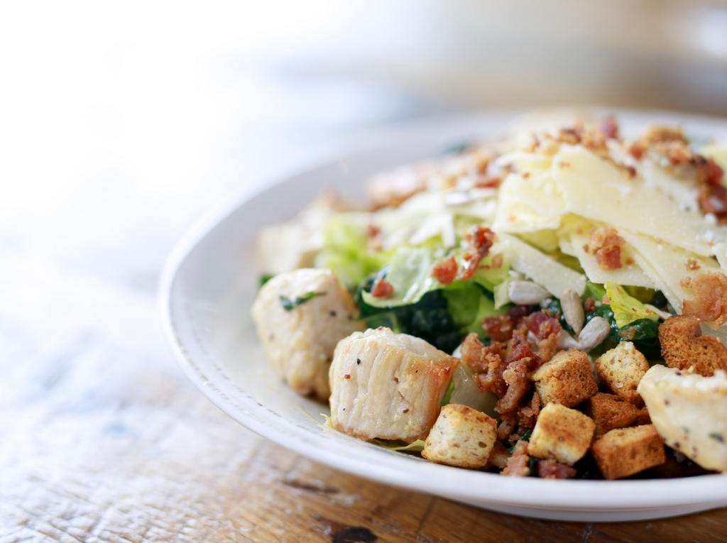 Kale Chicken Caesar · organic romaine & kale, sautéed all-natural chicken, organic tomato, sunflower seeds, nitrite-free bacon, croutons, shaved parmesan cheese, topped with caesar dressing