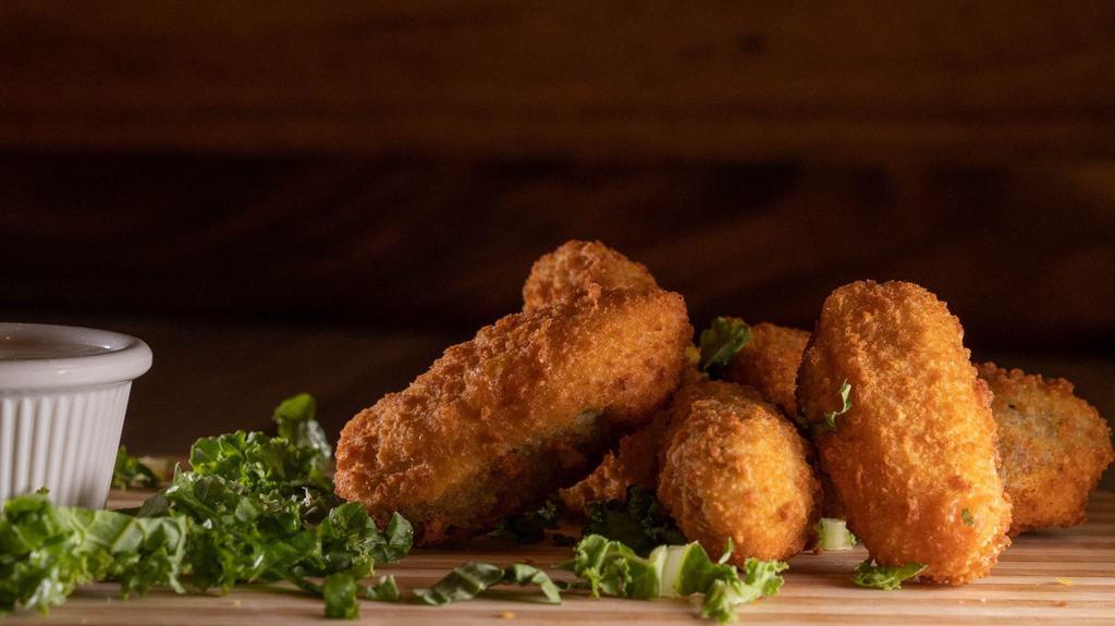 Jalapeño Poppers (6 Pcs.) · Six Jalapeño pepper halves stuffed with creamy cheddar cheese in a crunchy potato breading and served with our ranch dip