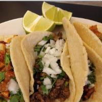 Tacos · An option of steak, spicy pork, spicy pork sausage or chicken served with onion and cilantro.