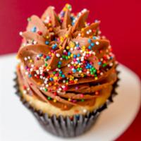 Vanilla Chocolate Cupcake · Vanilla bean cupcake frosted with chocolate buttercream, topped with chocolate paillettes.