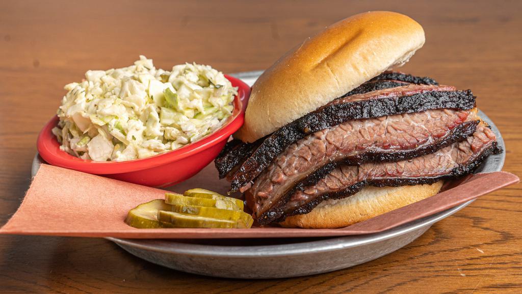 Brisket Sandwich · Sliced beef brisket on a soft bun, served with dill pickles and choice of one side.