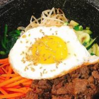Hot Stone Bibimbap · Rice, vegetable and egg in a hot stone bowl topped with sesame seeds and sesame oil with Kor...