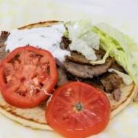 Gyro Wrap · Sliced meat served with fresh onions, tomatoes, and cucumber sauce on a fluffy pita. Served ...