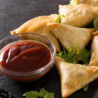 Vegetarian Samosas · Four pieces of filo dough filled with carrot, green onions, corn and potatoes.