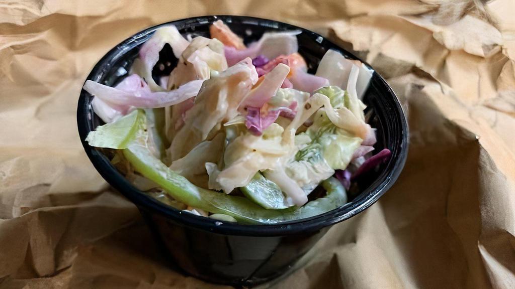 Creamy Cole Slaw · Filled with Red and Green Cabbage, Carrots, and Green Onions; lightly seasoned with Celery Seed, Salt, Black Pepper, then tossed with a semi-sweet creamy, tangy dressing.