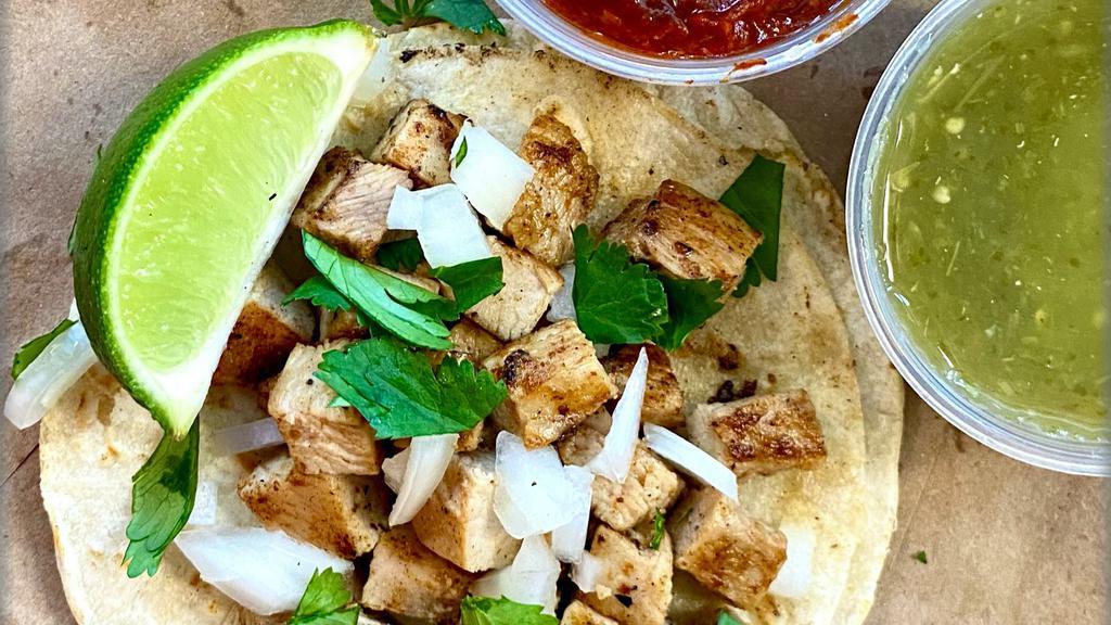 Chicken Taco · Double corn tortilla, grilled chicken with house dry spice rub, diced white onions, pulled cilantro & a lime wedge
