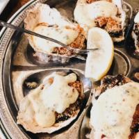 Oyster Rockefeller · Oysters, prosciutto, Parmesan, spinach, bread crumbs, Creole hollandaise.