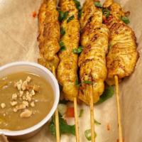 Chicken Satay · Gluten-free and Dairy-free. Marinated chicken skewered on a grill, garnished with cilantro a...