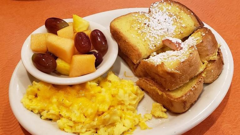 French Toast Sandwich · Two thick slices of sweet egg bread, custard dipped, two eggs, choice of meat. Served with cheesy hash browns, red potatoes or a side of fruit.
