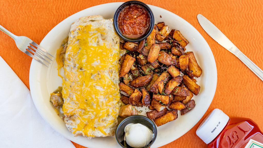 Smothered Burrito · Herb garlic tortilla filled with cheddar jack cheese, beans, onions, peppers and scrambled eggs. Smothered in our homemade pork green chili. Served with sour cream and salsa.