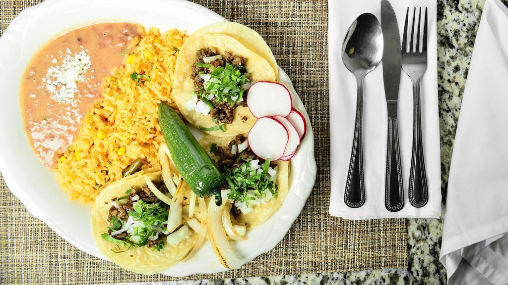 Tres Tacos Arroz Y Frijoles · Three tacos with rice and beans.