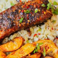 Jerk Salmon · Served with rice and peas cabbage and plantains.