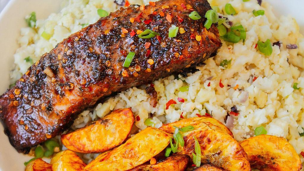 Jerk Salmon · Served with rice and peas cabbage and plantains.