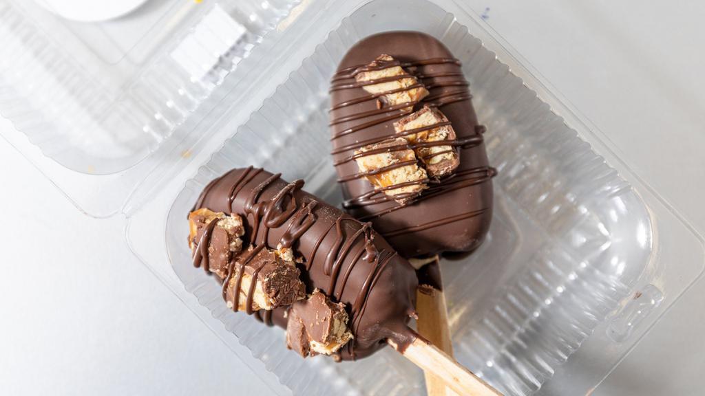 Snicker Cake Pop · 2 Chocolate cakesicles.  Dipped in Chocolate Drizzled with Caramel . Topped with Snicker Candy pieces