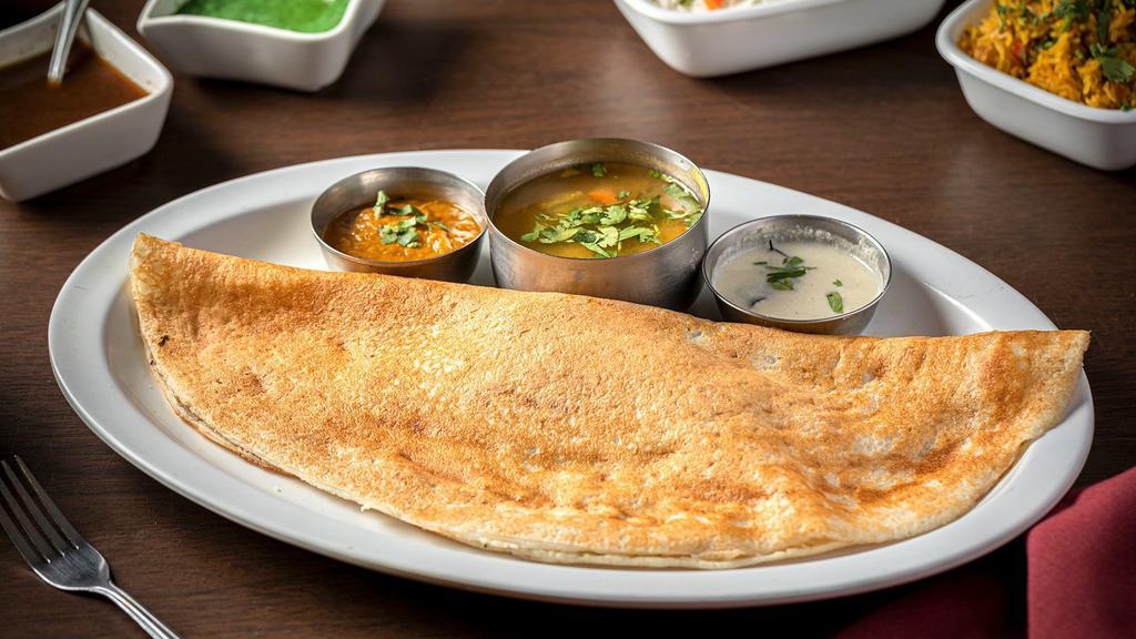 Masala Dosa · Vegan and gluten-free. A thin golden crepe stuffed with spiced Potato and Onion, served with Sambar and Coconut Chutney.
