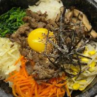 Dolsot Bibimbap · Steamed rice mixed with seafood and vegetables in a hot stone pot.