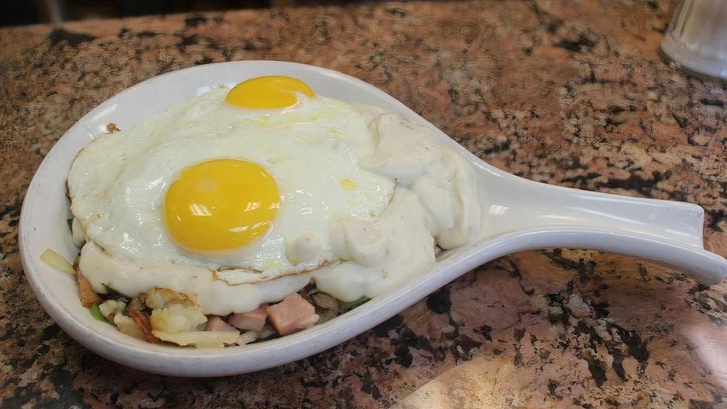 Hungryman Skillet · With hash browns, ham, bacon, sausage, onions, green peppers, country gravy and two eggs on top.