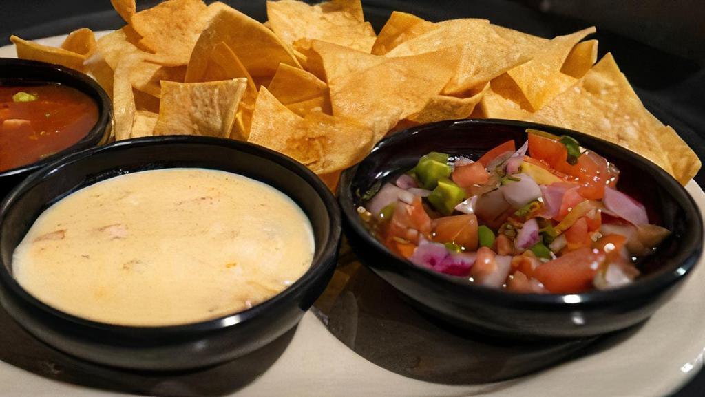 Chip Dip Trio · HTaco chips with queso, pico tomato salsa and black bean corn salsa on the side.